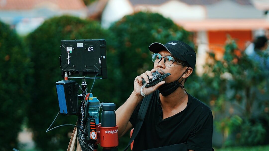 Reporter holding a microphone recording a piece to camera outdoors with a cameraman filming