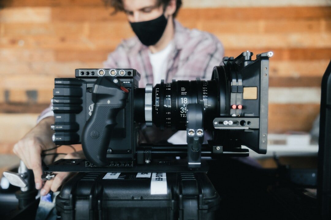 Camera operator adjusting settings on a professional video camera before a shoot