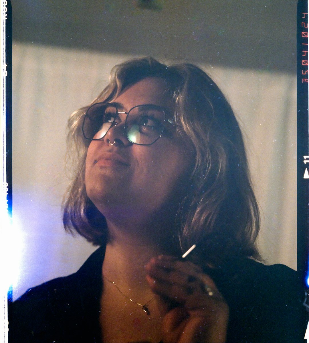 Studio portrait of a woman with curly hair wearing glasses